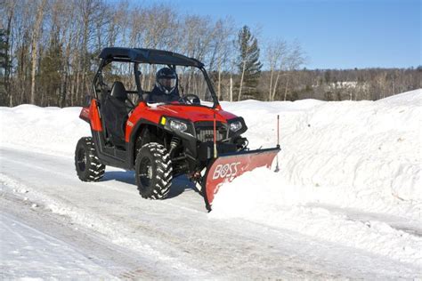 A Man Driving A Red Utensil Down A Snow Covered Road
