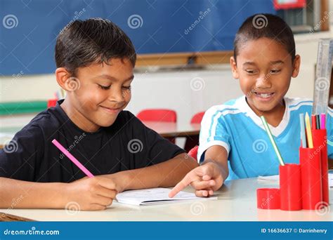 Two Schoolboys Helping Each Other Learn In Class D Royalty Free Stock