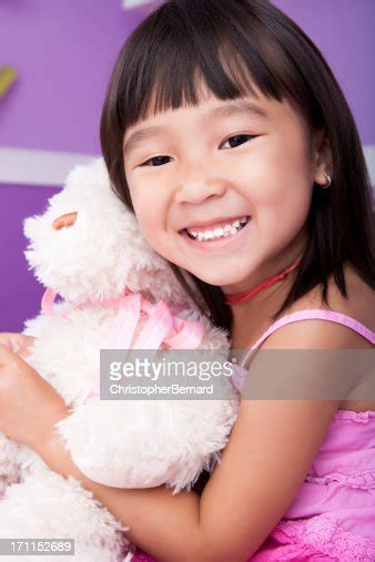Smiling Asian Girl Hugging Teddy Bear In Bed High Res Stock Photo