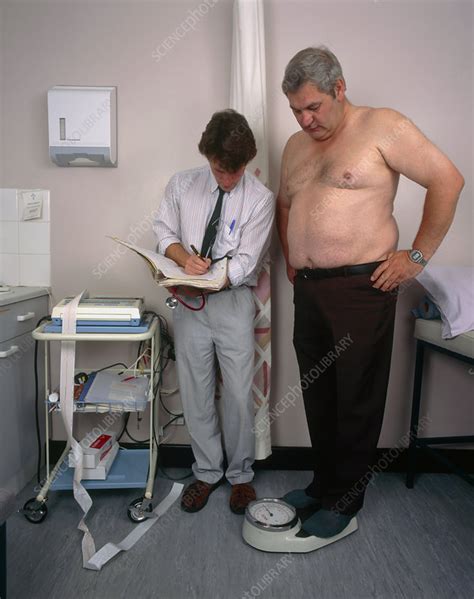 gp doctor records the weight of an obese man stock image m920 0528 science photo library
