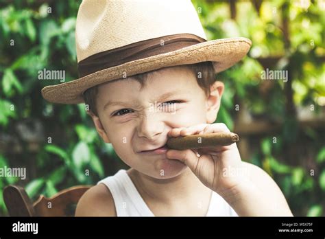 Beautiful Young Boy Plays Imitating An Adult Who Smokes A Cigar Funny