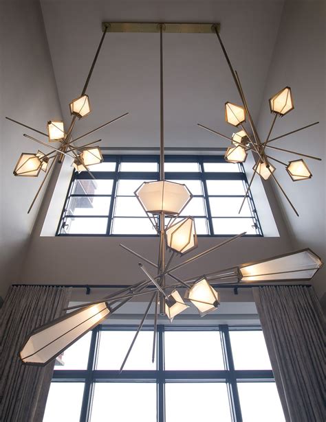 A Chandelier Hanging From The Ceiling In A Room With Large Windows And