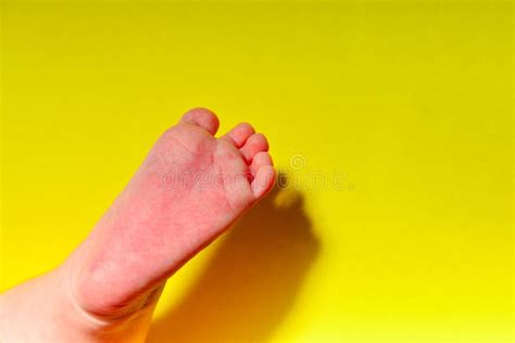 Baby Legs On A Yellow Background Small Leg Of A Newborn Baby Stock