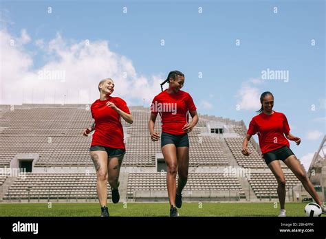 Group Of Female Football Players Training On Soccer Field Young Woman