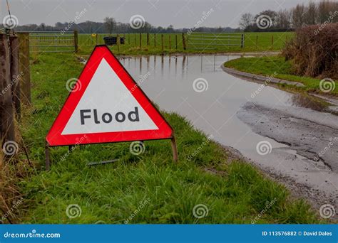 Flood A Flood Warning Road Sign Beside A Flooded Road Stock Photo