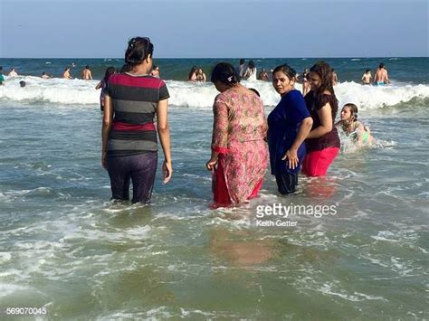 Women Getting Wet In The Ocean Water Wearing Their Street Clothes On