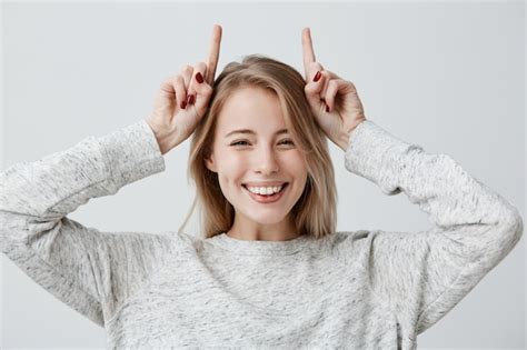 Free Photo Emotional Young Woman In Sweater Smiling Broadly Mocking