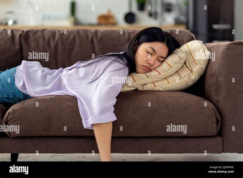 Tired Caucasian Young Woman Falls Asleep On Couch On The Couch After