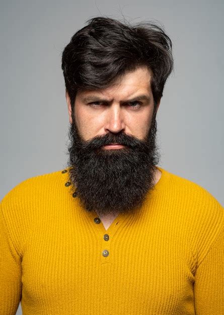 premium photo portrait of handsome serious man with beard and mustache looks seriously