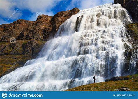 Person Standing At The Dynjandi Waterfall On The Westfjords Peninsula