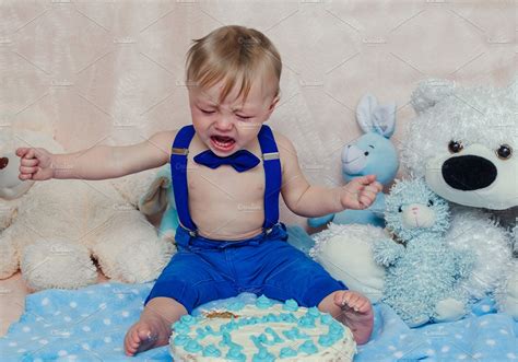 Baby Boy Crying While Eating His Birthday Party Cake Stock Photo
