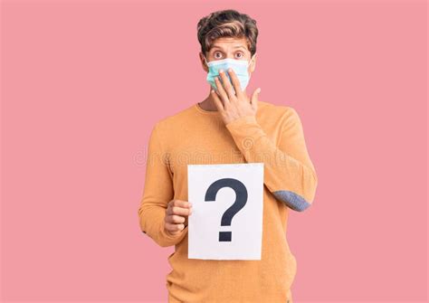 Young Handsome Man Wearing Medical Mask Holding Question Mark Covering