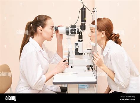 Ophthalmologist Doctor In Exam Optician Laboratory With Female Patient