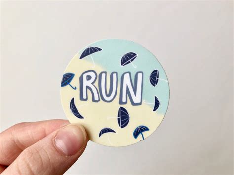 A Person Holding Up A Sticker With The Word Run On It