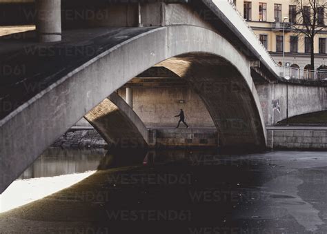 Person Walking Under Bridge During Winter In Stockholm Sweden Stock Photo