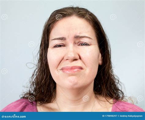 Suffering And Pain On The Face Of An Adult Woman Portrait On Grey Background Emotions Series