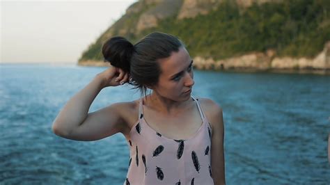 A Beautiful Girl Letting Her Long Brown Hair Down In Front Of The River