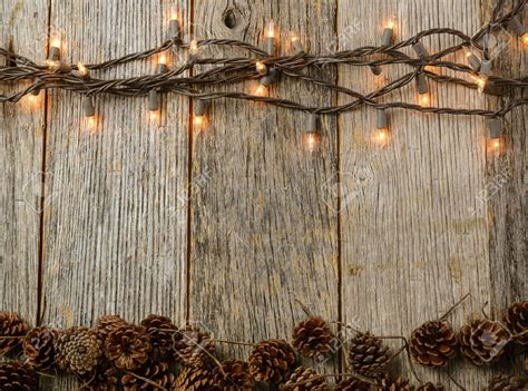 Christmas Lights And Pine Cones On Rustic Wood Background Rustic Wood
