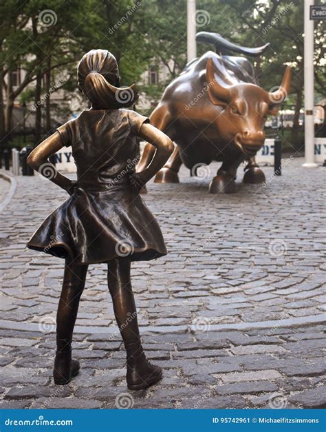 The Fearless Girl Statue Facing Charging Bull In Lower Manhattan New