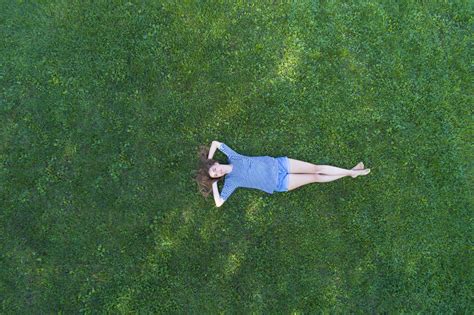 Young Woman Lying On Grass Daydreaming Stock Photo