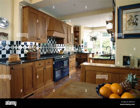 Fitted Oak Cupboards In Large Traditional Country Kitchen With Black