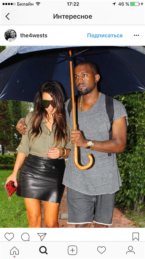 A Man And Woman Standing Under An Umbrella