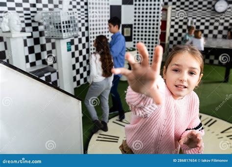 Tween Girl Holding Out Hand To Reach Out Something In Quest Room Stock