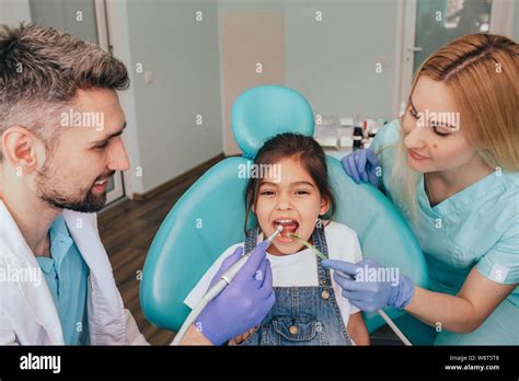 Assistants Helping Dentist In Treatment Patients Teeth In Medical