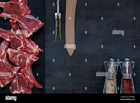 Raw Fresh Lamb Meat Ribs And Seasonings On Dark Background Stock Photo