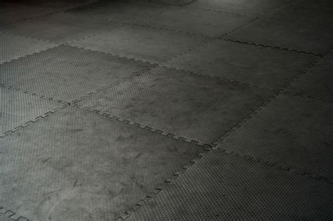 Choose the best special gym flooring for your home gym. Black rubber floor mat and tiles inside a gym. Black ...