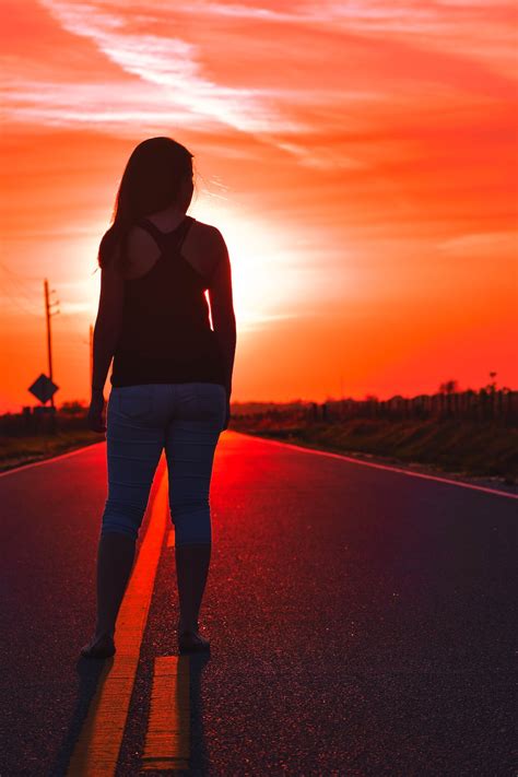 foto de mujer de pie en la carretera durante la puesta de sol imagen gratuita cielo en unsplash