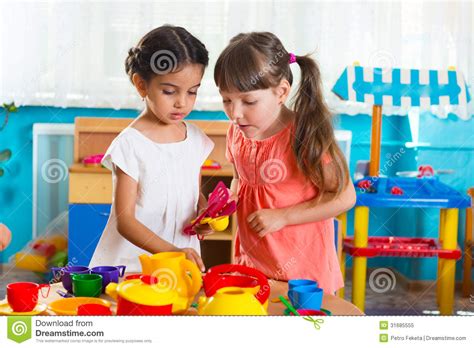 Thus, stripping games play an essential role in kids' learning process. Two Little Girls Playing In Daycare Royalty Free Stock ...