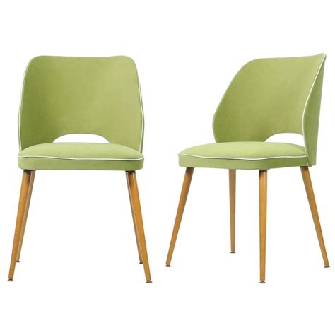 Two Green Chairs Sitting Side By Side On Top Of Each Other One With