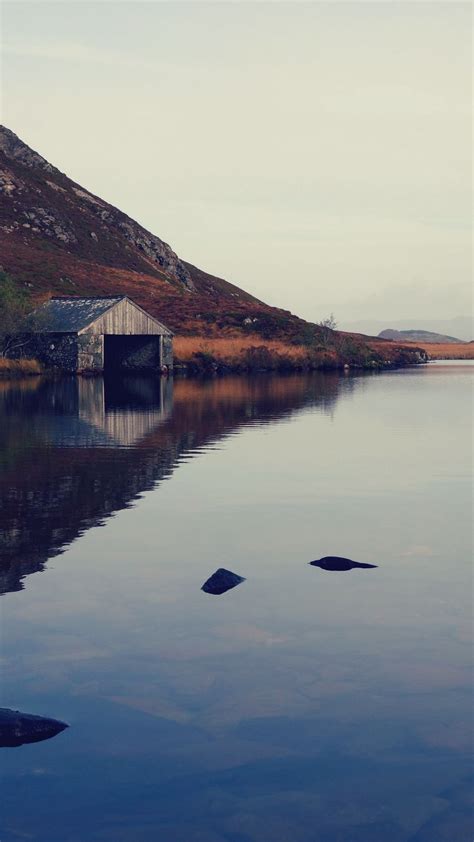 Download Wallpaper 938x1668 Lake Building Mountains Reflection