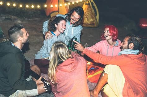 Group Of Friends Cheering And Toasting With Beer While Camping With
