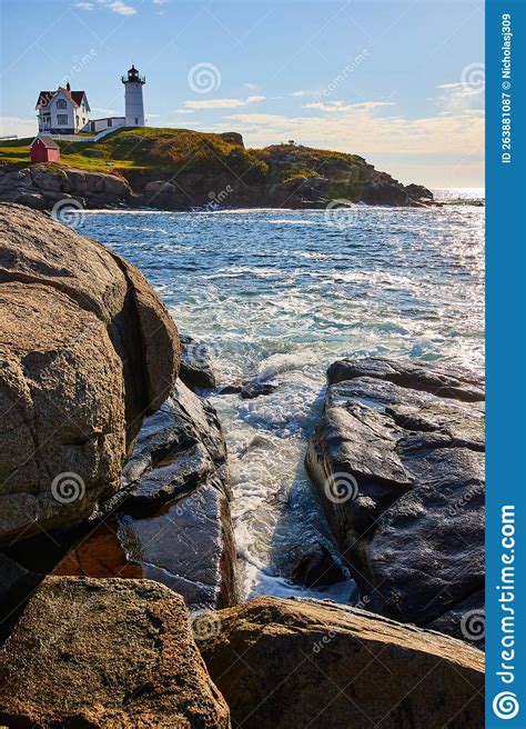 Ocean Waves Fill Crevice Of Rocky Maine Coasts With Lighthouse In