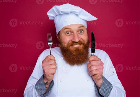 Happy Chef With Beard And Red Apron Holds Cutlery In Hand 20723990