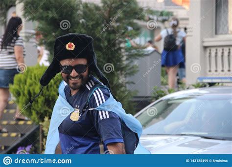 happy tourister football fan in national russian military winter hat with cockade hat ushanka