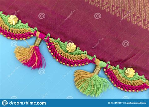 An Embroidered Fabric With Tassels And Beads On Blue Background Stock
