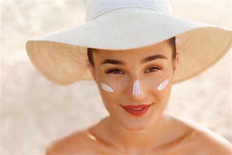 beauty woman smile applying sun cream on face skin care body sun protection sunscreen stock
