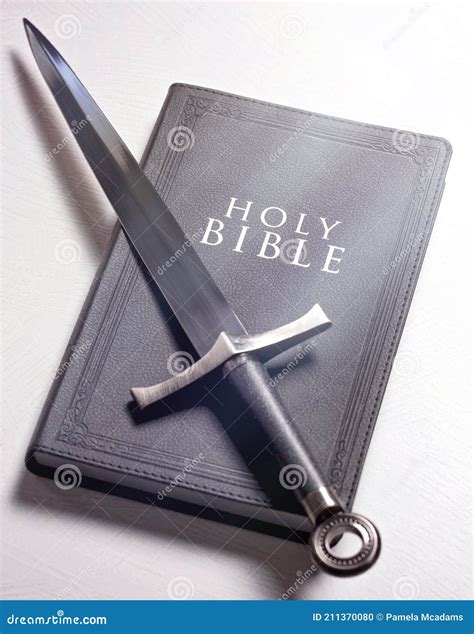 La Biblia Y La Espada Sobre Un Fondo Blanco Brillante Foto De Archivo