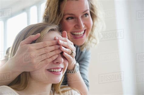 Caucasian Mother Covering Eyes Of Daughter Stock Photo Dissolve