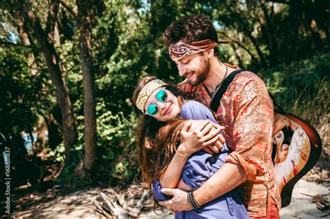 Beautiful Young Couple In Love In Hippie Style With The Guitar Resting