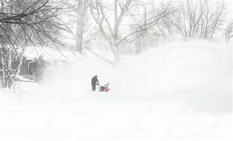 Distant Image Of A Man Snow Blowing His Driveway Stock Photo Download