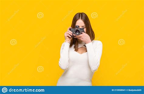Woman Holding Camera Over Yellow Background Girl Using A Camera Photo