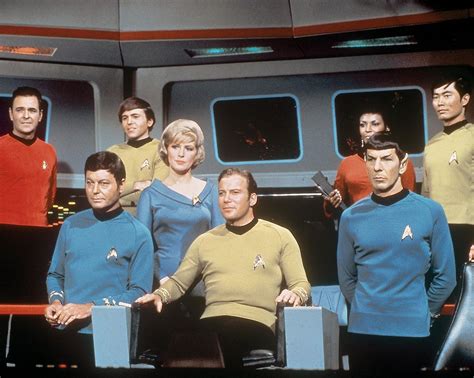 a group of people standing next to each other in front of a tv screen with the caption star trek