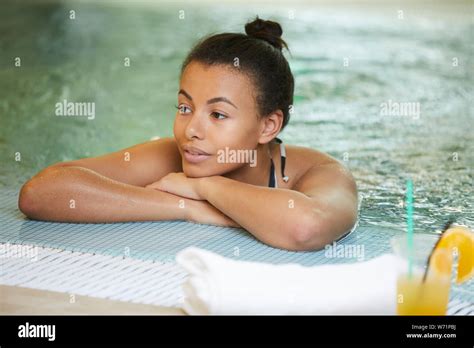 Portrait Of Beautiful Mixed Race Woman Relaxing In Swimming Pool Of Luxury Hotel Copy Space