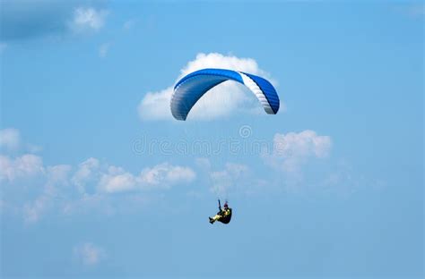 One Paraglider Flying In The Blue Sky Against The Background Of Clouds