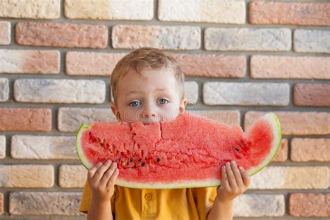 Funny Kid Eating Watermelon Indoors Focus On Eyes Stock Photo Image