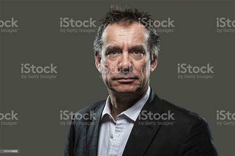 Glaring Angry Business Man In Suit On Grey Background Stock Photo